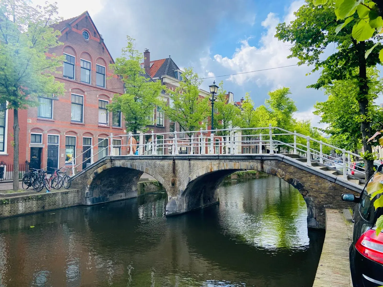 Een stenen boogbrug over een Delftse gracht, een van de plekken op de stadswandeling Hoogtepunten van Delft