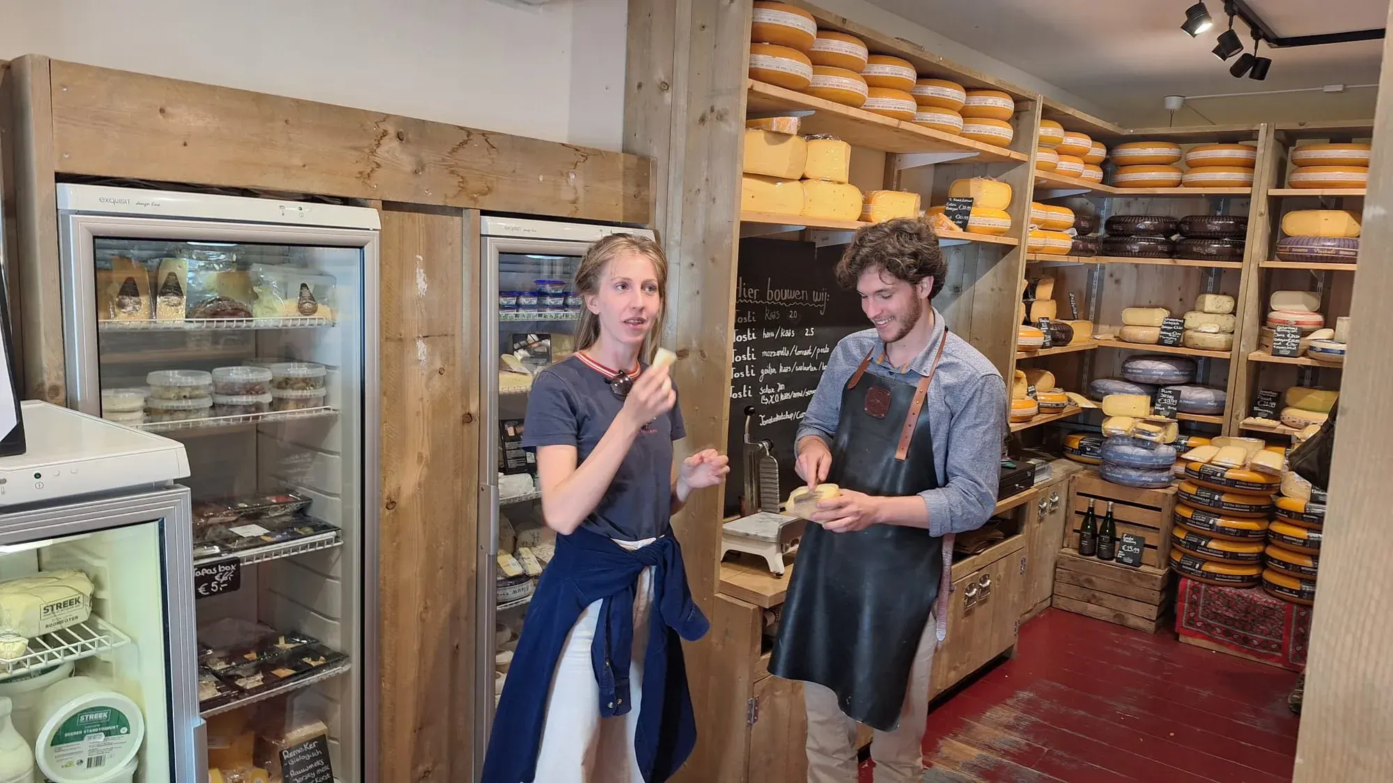 A guest tasting Dutch cheese with the cheesemonger on the private food and drink tour in Delft