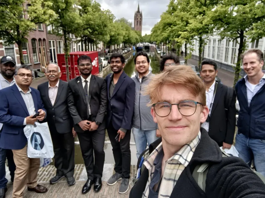A corporate team building group photographed on a canal bridge during their walking dinner in Delft