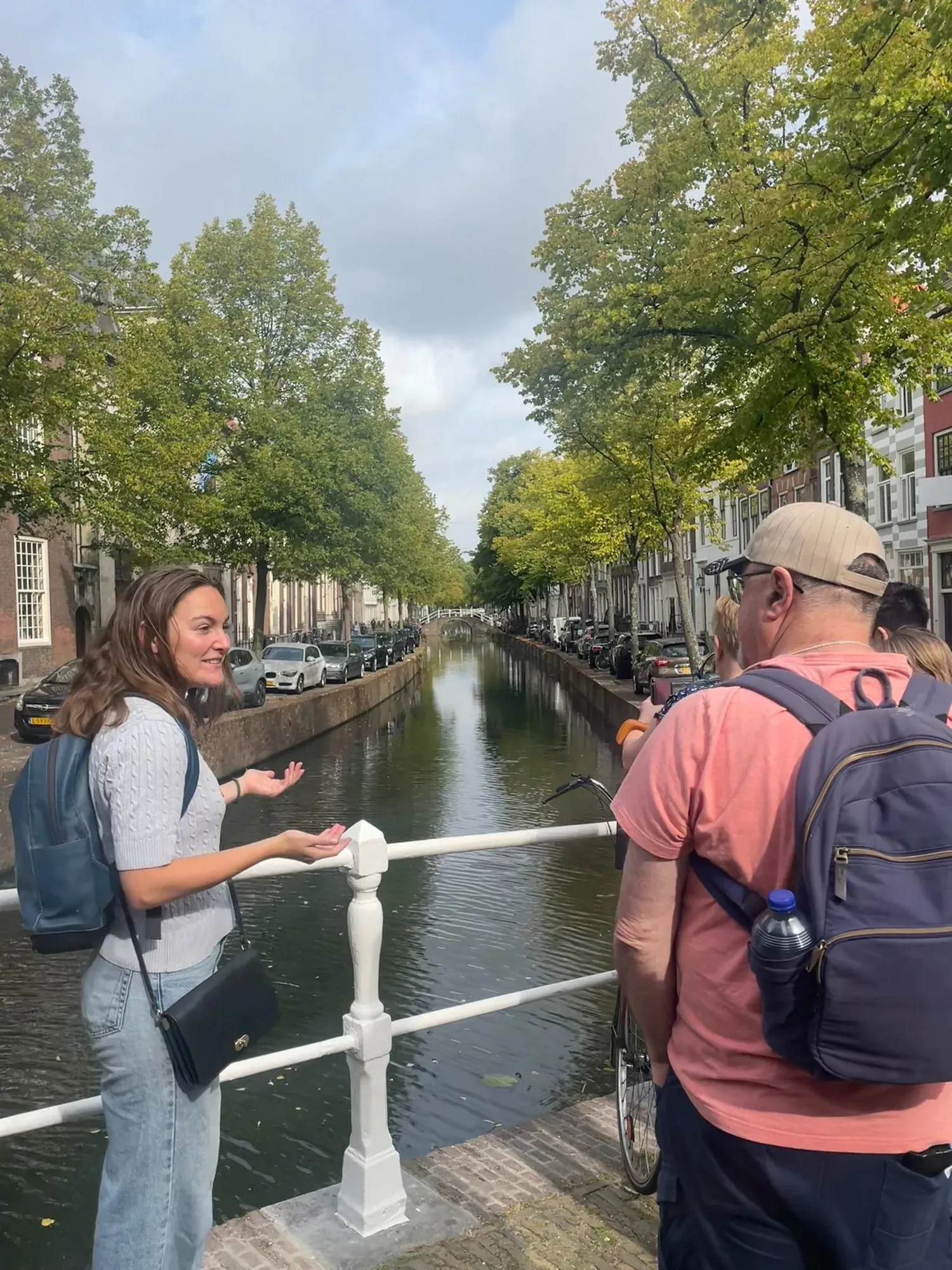 A Discover Delft guide explaining a canal bridge to a small group