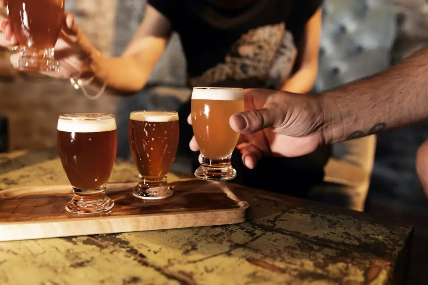 A flight of three Dutch beers served on a wooden board during a custom team building day in Delft