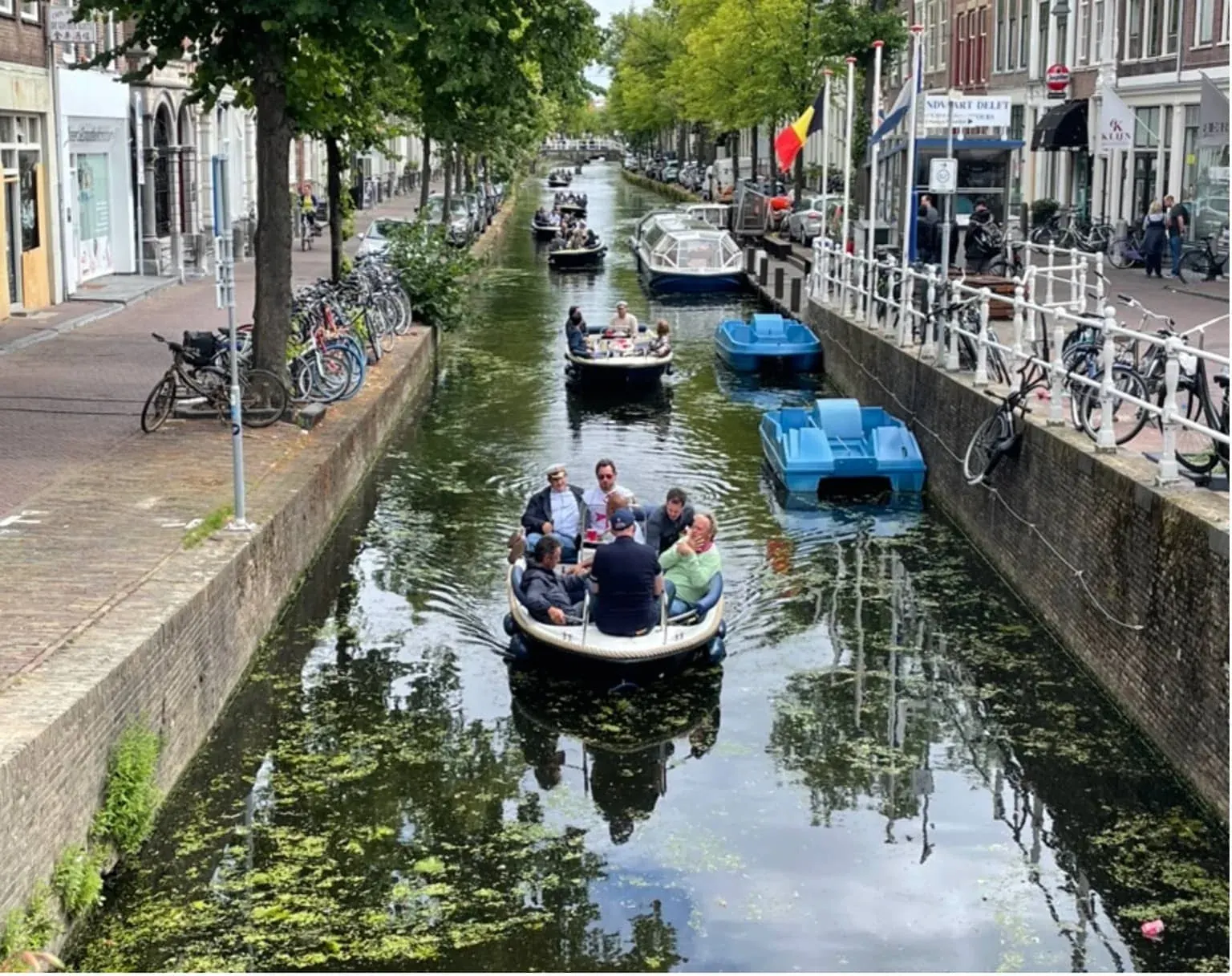 A canal tour boat on a Delft canal, seen from a bridge