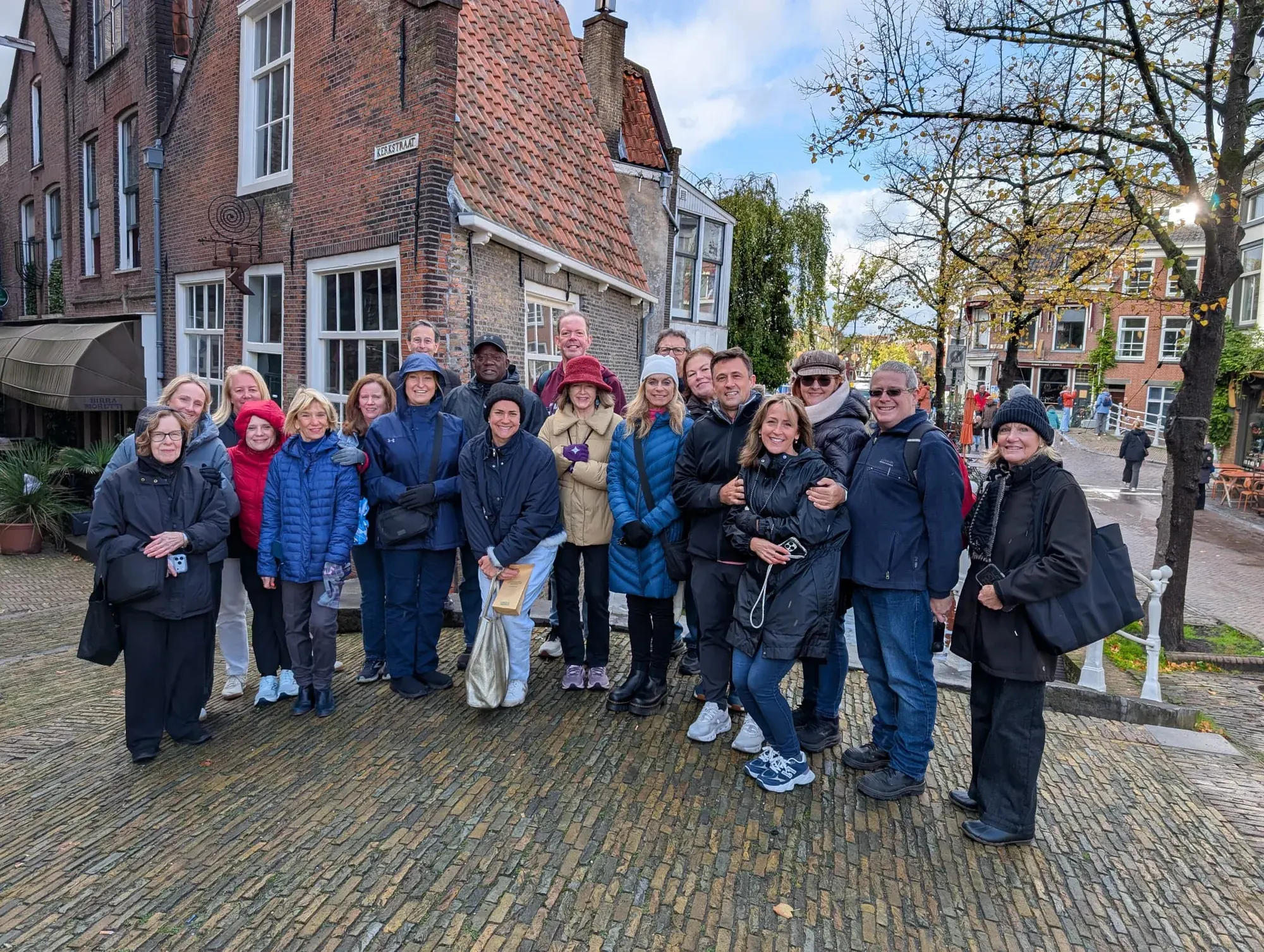 A tour group photo in the Kerkstraat in Delft, with the old brick houses behind