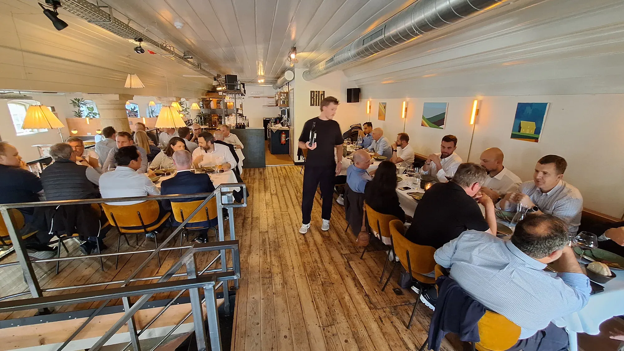 A company group at long tables during the main course of a walking dinner in Delft