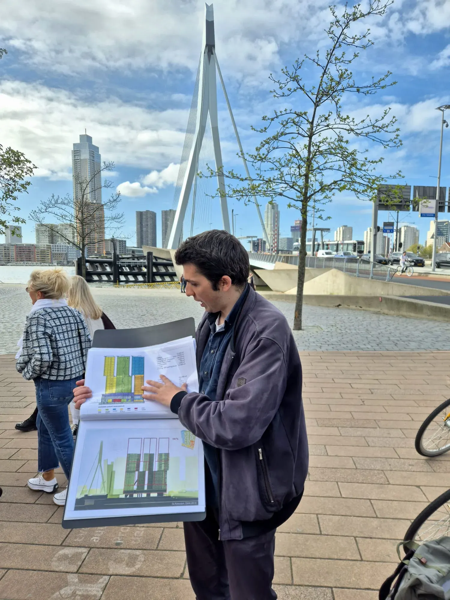 A guide talking to a small group in front of the Erasmus Bridge in Rotterdam