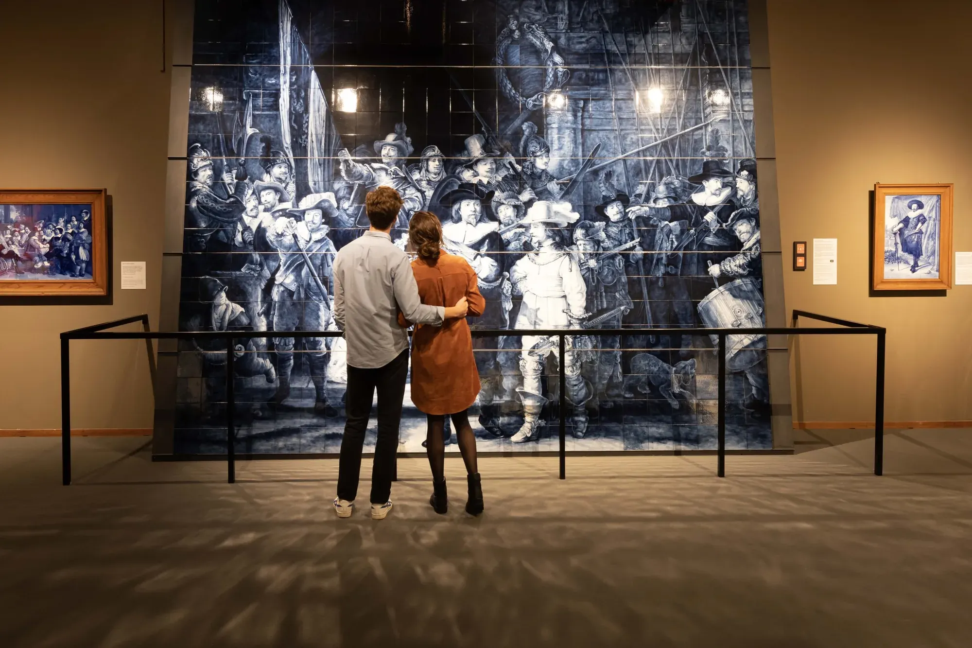 Visitors in front of the hand-painted Night Watch tile mural at Royal Delft in Delft