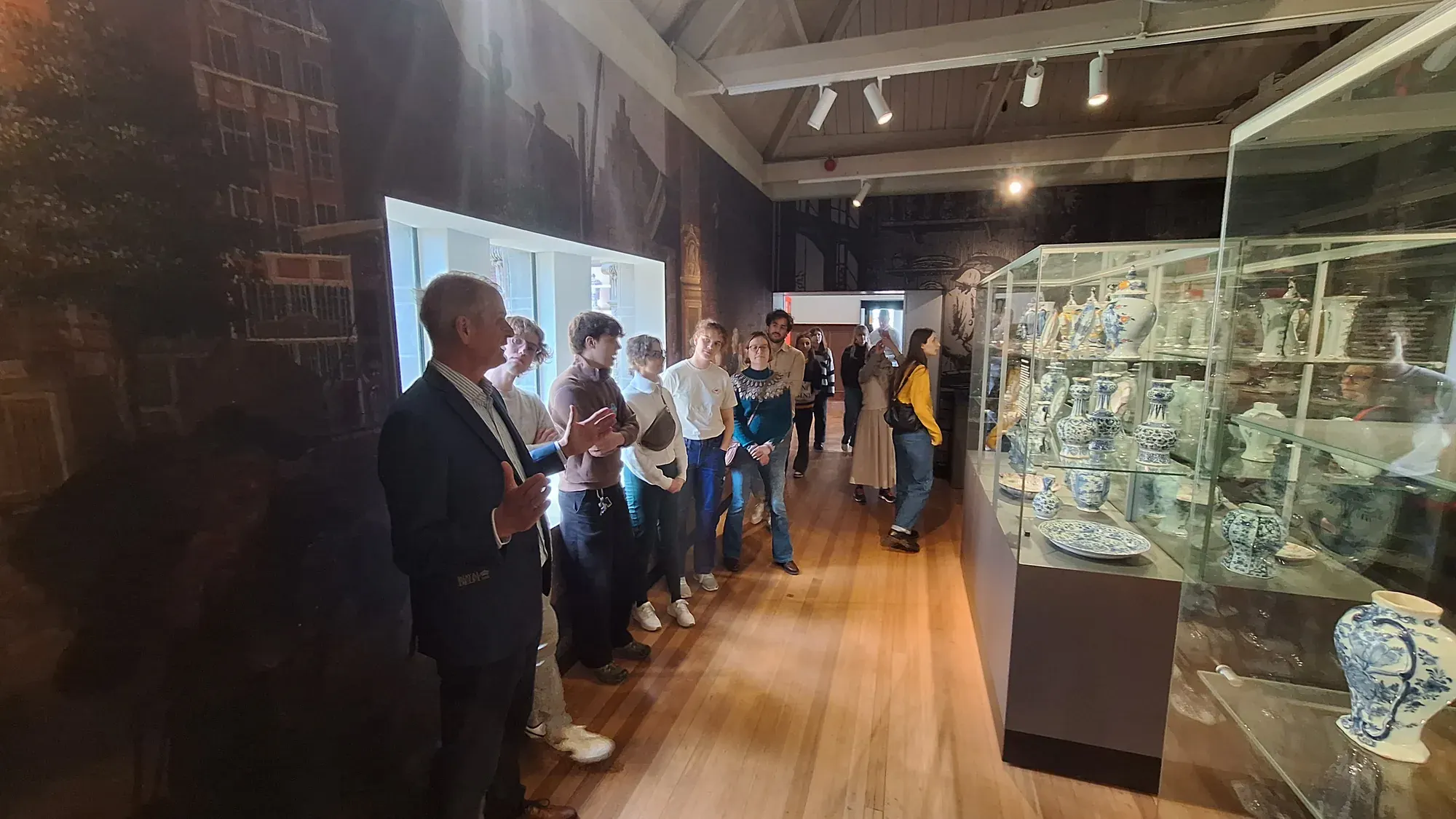 A tour group with a guide in the Royal Delft museum gallery, part of the Delft at its Best team building day