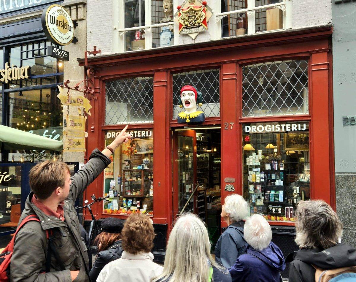 Guide and group in The Hague in front of an old chemist, during a private city tour.
