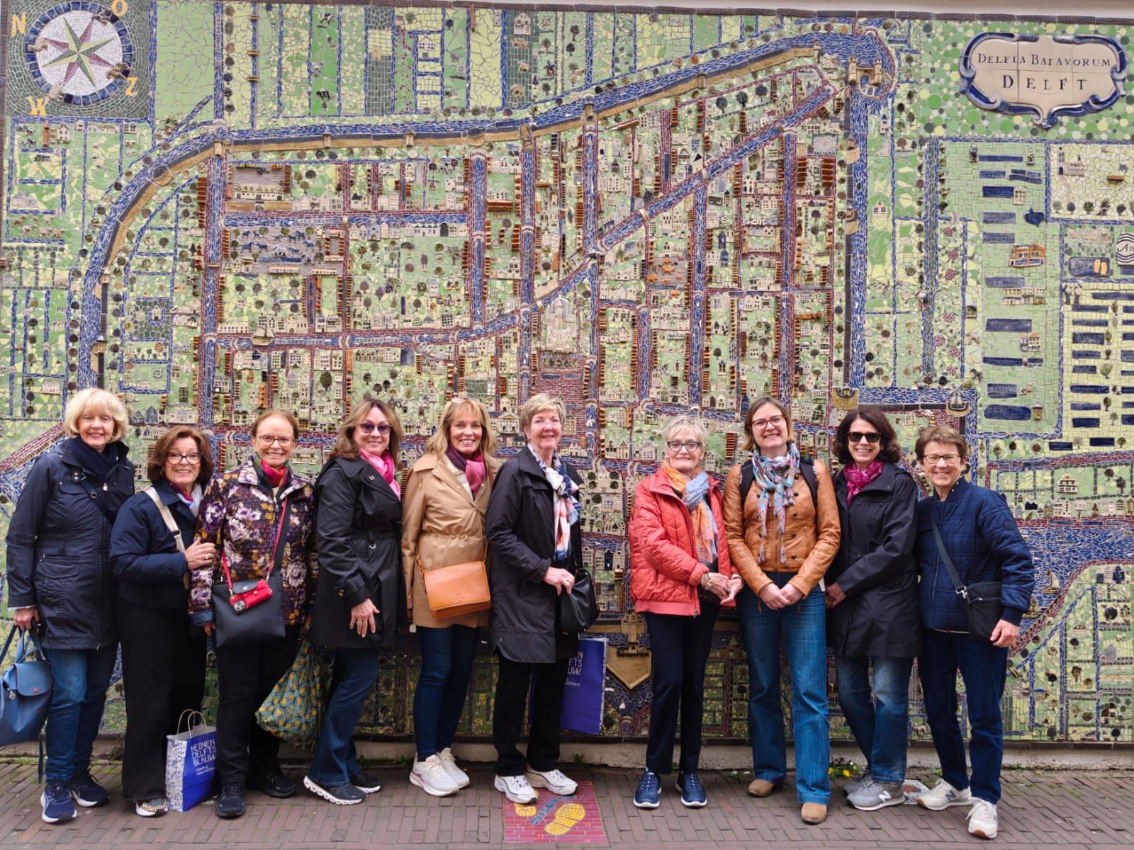 Ladies posing in front of map of Delft during a private walking tour.